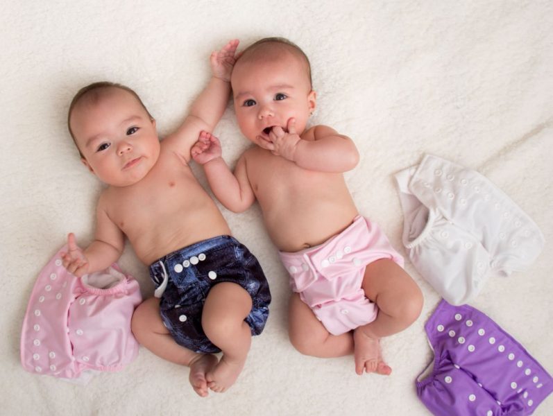 Två bebisar med färggladaa tygblöjor.